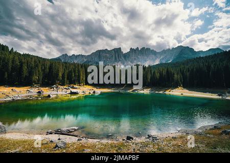 Paesaggio mozzafiato lago turchese Alpino Carezza circondato da boschi di conifere con il Monte Latemar, provincia di Bolzano, Alto Adige, Italia Foto Stock