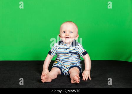 Bambino di 10 mesi su sfondo verde pt 3 Foto Stock