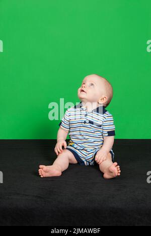 Bambino di 10 mesi su sfondo verde pt 4 Foto Stock