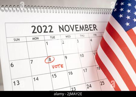 Novembre 2022 USA Vote Day Concept. Calendario da tavolo con il 8 novembre contrassegnato in rosso e bandiera USA Foto Stock