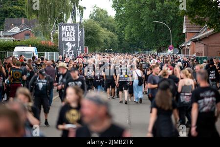 Wacken, Germania. 05th ago 2022. Migliaia di visitatori del festival sono ai margini del Wacken Open Air Festival nella città di Wacken. Il WOA è considerato il più grande festival del metallo pesante del mondo. Credit: Daniel Reinhardt/dpa/Alamy Live News Foto Stock