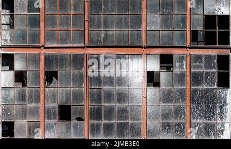 Vecchio muro dell'edificio con finestre sporche e rotte Foto Stock