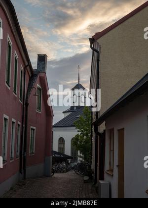 Una strada stretta tra le case che conduce alla famosa chiesa di Vardklockan a Visby, sull'isola di Gotland in Svezia Foto Stock