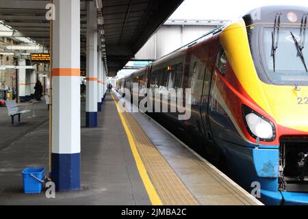 Uno scatto di un treno delle East Midlands in attesa su una piattaforma con passeggeri in una stazione ferroviaria di Sheffield, South Yorkshire, Inghilterra Foto Stock