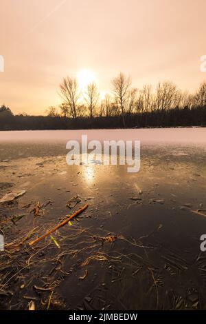 Incrinature sulla superficie del ghiaccio blu. Lago ghiacciato nel paesaggio invernale delle montagne Foto Stock