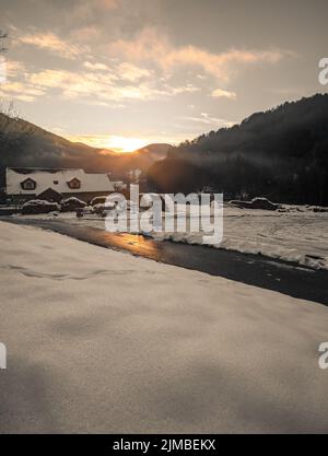 Fantastic evening winter landscape glowing by sunlight. Dramatic wintry scene during sunset Foto Stock