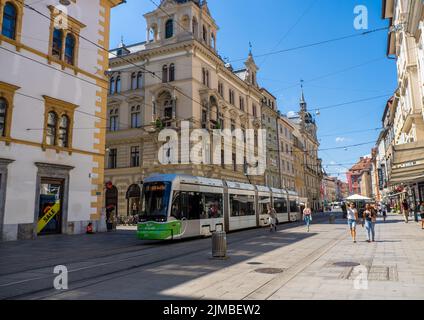 Un tram e persone su una strada principale nel centro della città di Graz, Austria Foto Stock