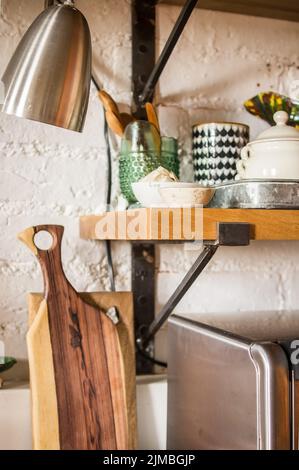 Vista su una moderna cucina in stile japandi con diversi oggetti in ceramica, utensili e vasi decorativi Foto Stock