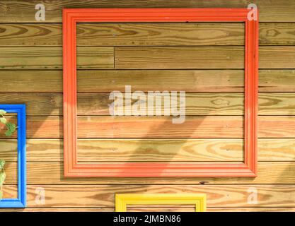 Cornice fotografica colorata dipinta appesa alla parete del pallet in legno Foto Stock