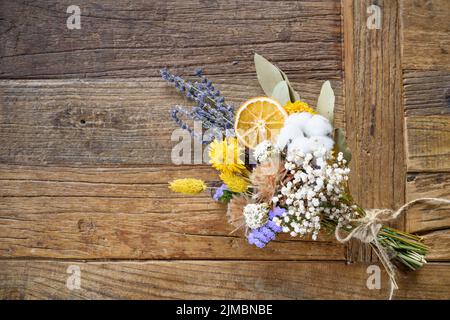 Fiori secchi in bouquet su sfondo di legno Foto Stock