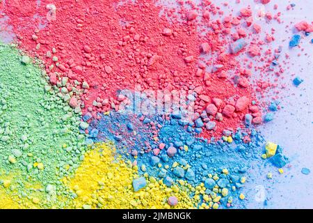 Sfondo colorato di polvere di gesso. Particelle di polvere multicolore che si infranono su sfondo bianco. Foto Stock