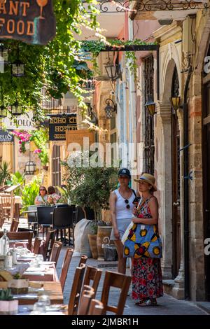 turisti e visitatori che navigano tra le bellissime e interessanti vie dello shopping storico della città di rethymno, sull'isola greca di creta. Foto Stock