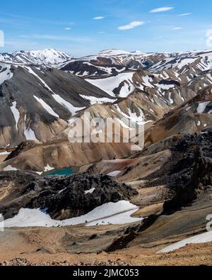 Una splendida vista sulle montagne vulcaniche innevate con un piccolo lago in Islanda Foto Stock
