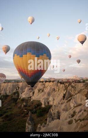 29 giugno 2022, Turchia, Göreme: Palloncini ad aria calda che volano all'alba di fronte ad un altopiano di roccia. Foto: Sebastian Kahnert/dpa Foto Stock