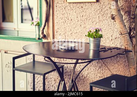 Vaso di primule in fiore su un tavolo esterno. Foto Stock