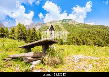 Panorama montano con tavolo e panche per riposo e crocifisso. Foto Stock