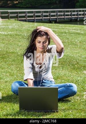 Donna con computer portatile nel parco estivo Foto Stock