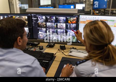 Friburgo, Germania. 05th ago 2022. Gli agenti di polizia si siedono di fronte al monitor di sorveglianza di diverse videocamere. La polizia di Friburgo ha installato una rete di telecamere in una zona molto frequentata di notte, che sono ormai in funzione da poco tempo. Credit: Philipp von Ditfurth/dpa - ATTENTION: Deployment data pixelated on the monitor/dpa/Alamy Live News Foto Stock