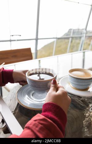 con una tazza di porcellana con caffè, tavolo servito con stoviglie decorate in blu chiaro, bevanda calda nel ristorante, stile di vita per la colazione Foto Stock
