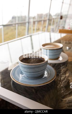 tavolo servito con tazza di caffè e latte, stoviglie decorate in blu chiaro, bevanda calda nel ristorante, colazione con caffeina Foto Stock