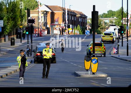 Londra, Regno Unito, 5th agosto, 2022. Le indagini della polizia sono state viste funzionare a seguito di una risposta della polizia armata dopo le segnalazioni di un uomo che trasportava un condotto di armi da fuoco-nastrato alla sua mano. Dopo che un occhio ha visto un gomma che è stato attivato che non ha avuto effetto, l'uomo è stato girato e un trattato sulla scena per le sue lesioni, prima di essere airlifed all'ospedale dove la sua condizione è sconosciuta. Si ritiene che l'incidente non sia collegato al terrore. Credit: Undicesima ora Fotografia/Alamy Live News Foto Stock