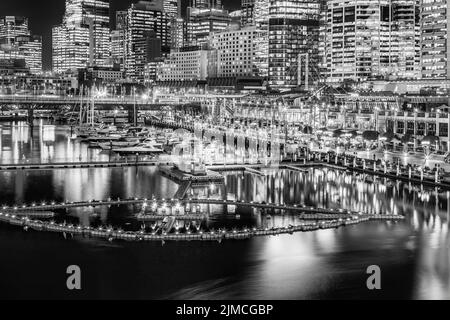 Scenico lungomare di Darling Harbour bianco e nero ad alto contrasto nel CBD di sydney al tramonto con fontana galleggiante sulla baia di Coockle. Foto Stock