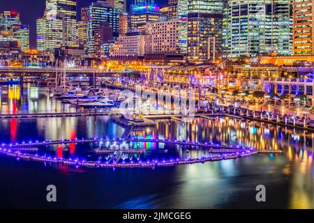 Scenico e luminoso lungomare di Darling Harbour nel CBD di sydney al tramonto con fontana galleggiante sulla baia di Coockle. Foto Stock