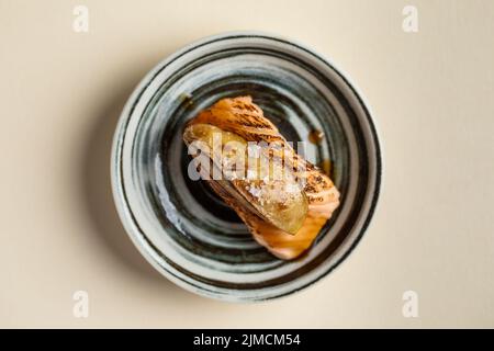 Vista dall'alto del gustoso sushi nigiri giapponese Horwegian con salmone affumicato e foie gras flambeed servito sul piatto del ristorante Foto Stock