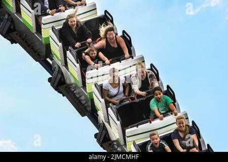 Crange, Herne, NRW, 05th ago, 2022. La gente urla e si diverte sulle montagne russe 'Alpinabahn'. Il giorno di apertura ufficiale della Cranger Kirmes del 2022, la più grande fiera del 3rd della Germania e la più grande del suo genere in NRW, vede migliaia di visitatori che si divertono con giostre, montagne russe, birrerie, bancarelle di cibo e altre attrazioni. La fiera popolare, che è stata messa in pausa durante la pandemia, attira regolarmente più di 4m visitatori durante i suoi 10 giorni di funzionamento ed è stata istituita per decenni nella sua forma attuale, con la fiera stessa che risale ai primi 18th secolo a Crange. Credito: Imageplotter Foto Stock