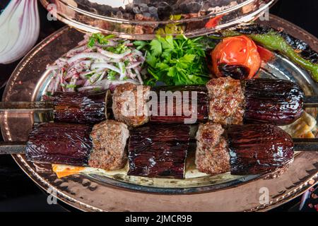 Kebab turchi tradizionali. Kebab di melanzane, kebab di Adana. Con pomodori, peperoni, aglio, pilaf bulgur ed erbe.Nome turco; kebab patlicano, kebab adana Foto Stock