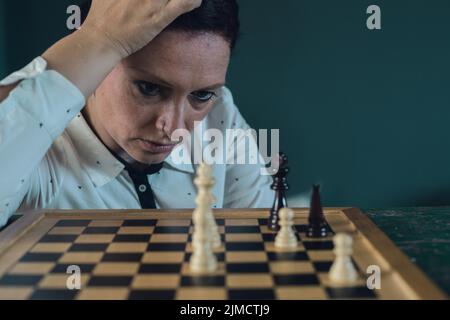 Immagine del simbolo, disperazione, successo, confusione, strategia, donna con un set di scacchi Foto Stock