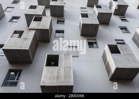 Da sotto l'esterno di casa residenziale con finestre e vari balconi grigi situati sulla strada della città Foto Stock
