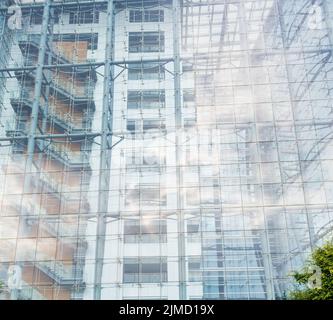 Sfondo architettonico di un alto e moderno edificio con una facciata di vetro chiaro Foto Stock