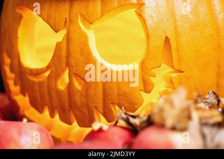 L'atmosfera diabolica di Halloween è rappresentata da una lanterna di jack a testa di zucca nelle mele e nell'autum secco Foto Stock