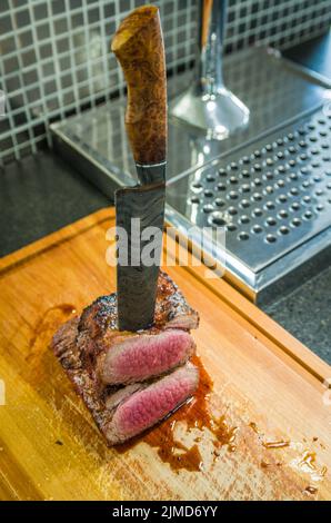 Bellissima foto di brisket di manzo (punta di Brisket fine). Taglio di carne con coltello in acciaio Damasco forgiato Arkan Foto Stock