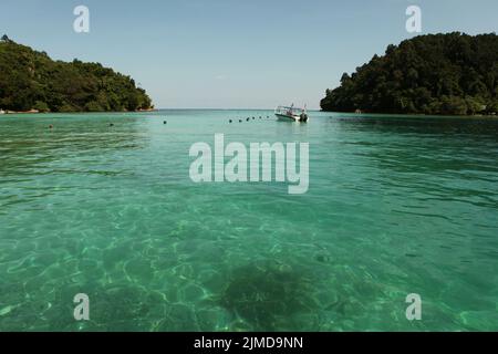 Una barca turistica è visto sul mare vicino Pulau Sapi (Isola Sapi), una parte del Parco Tunku Abdul Rahman a Sabah, Malesia. Foto Stock