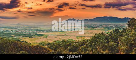 Splendida vista sul campo di riso e sulle montagne al tramonto. Panorama Foto Stock