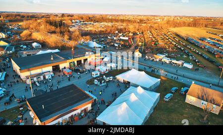 Vista aerea di un fango Amish sale con un sacco di Buggy e attrezzature agricole in un giorno invernale di prima mattina Foto Stock