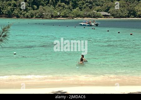 I visitatori hanno tempo libero sulla spiaggia di Pulau Sapi (Isola Sapi), una parte del Parco Tunku Abdul Rahman a Sabah, Malesia. Foto Stock