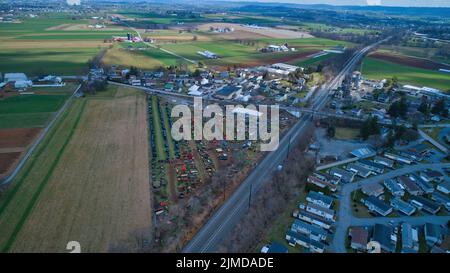 Vista aerea di un fango Amish vendita con un sacco di Buggies e attrezzature agricole Foto Stock