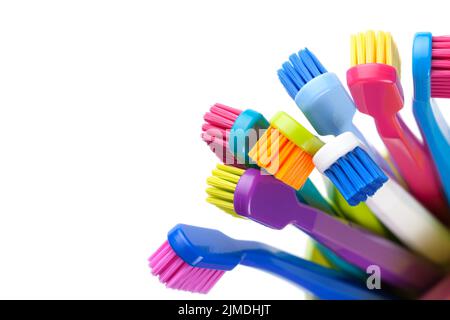 Gruppo di spazzolini colorati in tazza isolato Foto Stock