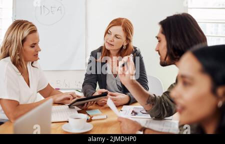 Tutti hanno un'idea brillante da condividere: Una donna d'affari matura che ha un incontro con i suoi colleghi in un ufficio. Foto Stock