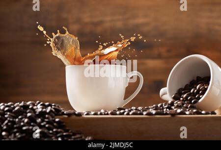 Mi piace il caffè riempito fino al bordo: Due tazze su sfondo di legno pieno di caffè e chicchi di caffè. Foto Stock