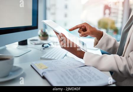 Il businessperson lavora con un tablet digitale alla scrivania di un ufficio moderno. Primo piano di documenti professionali in multitasking o di controllo Foto Stock