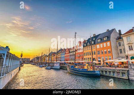 Copenhagen Danimarca, skyline della città al tramonto al porto di Nyhavn con una casa colorata Foto Stock