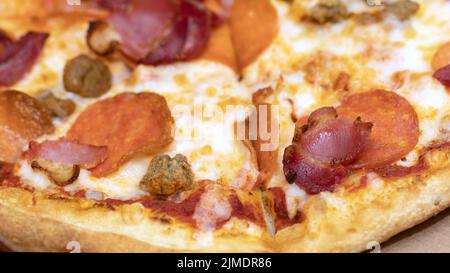 Pizza con salame, prosciutto, manzo Foto Stock