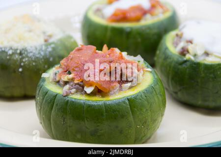 Zucchine farcite con carne e una varietà di salse Foto Stock