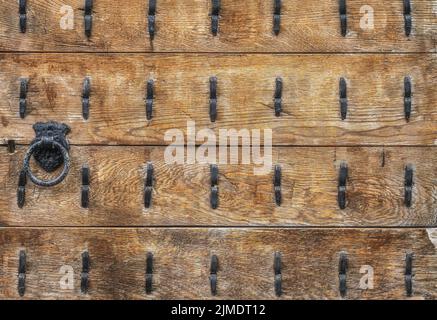 Porta in legno vintage, ghisa, ad anello, maniglia e borchie in ferro Foto Stock