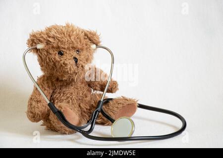 teddy orso bruno m stetoscopio su sfondo isolato, pediatria, medico dei bambini, medicina e scienza Foto Stock