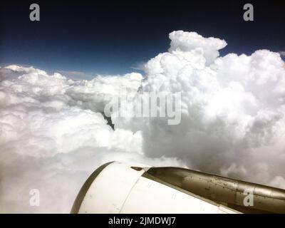 Una bella vista notturna nuvolosa dalla finestra di un aeroplano con il motore visibile nello scatto Foto Stock